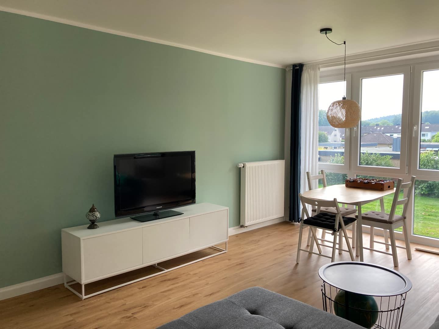 Helles Wohnzimmer der Ferienwohnung mit Blick ins Grüne